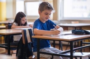 Ученик попълва заявление за еднократна помощ в училищен кабинет