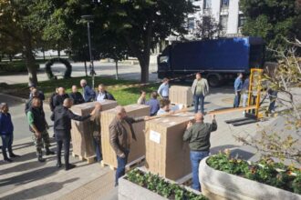 Илюстрация на подредени хартиени бюлетини с българското знаме и сини геометрични акценти на KANAL7.BG.